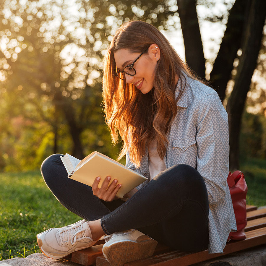 A young woman reads a book